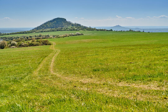 Pasture grazing land in scenic nature with view of Central Bohemian Highlands (Czech: Česk&eacute; Středohoř&iacute;) mountains of Radobyl and Hazmburk castle. Popular natural reservation and holiday destination.