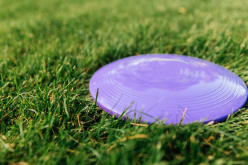 leisure games, toys and sport concept - close up of flying disc on grass