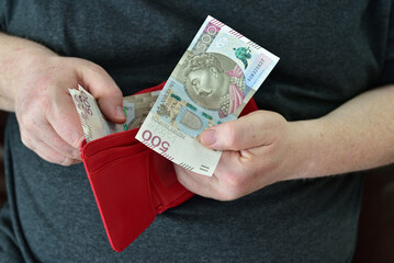 Hands holding wallet with polish currency money. Concept of financial security in old age during retirement