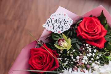 Close up of a beautiful bouquet of roses with a happy mothers day card. Mother's Day, concept of congratulations on the holiday.gift card