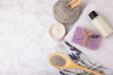 Fototapeta premium Lavender spa.Sea salt,lavender flowers,aroma candle,body cream and handmade soap.Natural herbal cosmetics with lavender flowers on marble background.Relax concept.Beauty treatments.Copy space.