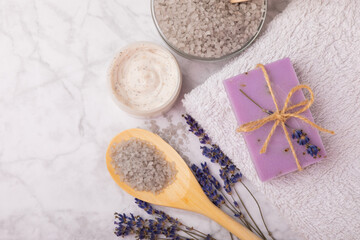 Fototapeta na wymiar Lavender spa.Sea salt,lavender flowers,aroma candle,body cream and handmade soap.Natural herbal cosmetics with lavender flowers on marble background.Relax concept.Beauty treatments.Copy space.