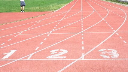 red running track start with starting numbers of running race between athletes in sport competition