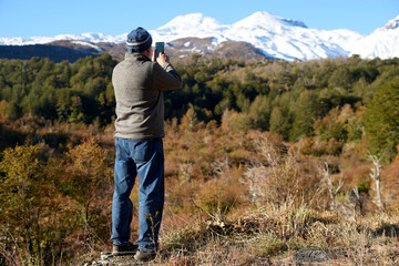 Fototapeta na wymiar Senior adult seen from behind enjoying the landscape formed by the snowy mountains