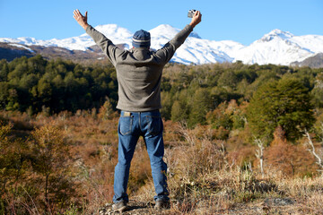 Senior adult seen from behind enjoying the landscape formed by the snowy mountains