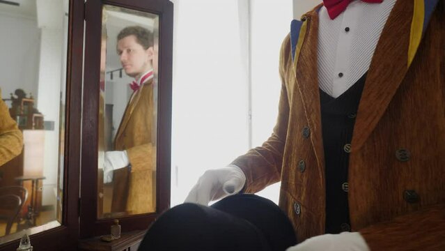 The man is a magician. Stock footage. A young actor in a brown suit with a hat who is assigned to the performance. Generative AI