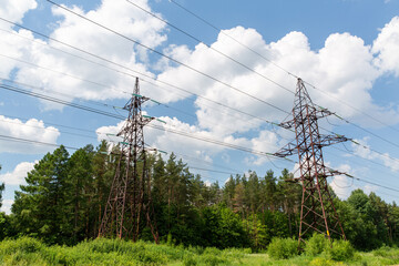 power line and electricity concept - transmission tower over blue sky