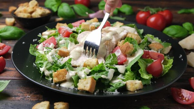 Eating a delicious chicken caesar salad. Healthy food