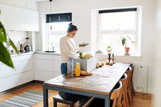 Woman unpacking a delivery box of groceries
