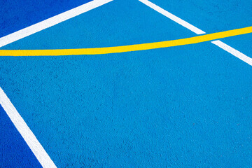Sport field court background. Blue rubberized and granulated ground surface with white, yellow lines on ground. Top view