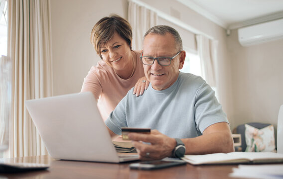 Im so glad we invested in ourselves. a mature man using his bank card to make online payments.