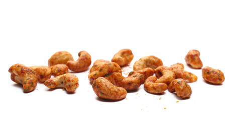 Spicy cashews nuts pile with chili   isolated on white, side view