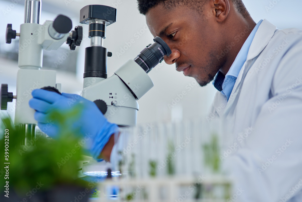 Poster looking into a whole new world. a focused young male scientist looking at test samples through a mic