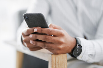 Lets see what landed in my inbox. Closeup shot of an unrecognisable businessman using a cellphone in an office.