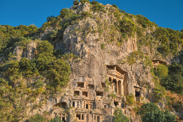 Lycian rock tombs in the city of Fethiye on the Aegean coast of Turkey, Lycian tombs at sunset in spring, the rock-cut tombs of Amyntas rise above the city, travel and vacation time