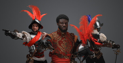 Shot of multicultural squad of medieval spanish knights against gray background.