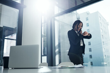 Let your talent do the talking. a young businesswoman using a smartphone and checking the time in a modern office.