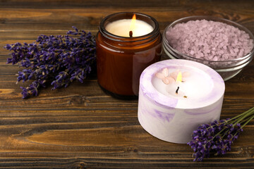 Obraz na płótnie Canvas Lavender spa. Sea salt, lavender flowers, scented candle. Natural herbal cosmetics with lavender flowers on a wooden background.Place for text.