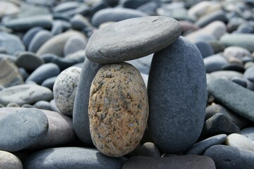 Fototapeta na wymiar The tower is made of various pebbles on a stony beach.