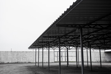 Parking for cars from iron profiles and roofs, on a city street on a cloudy day. Image for your design or creative illustrations.