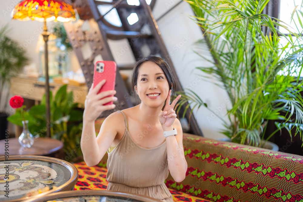 Poster Woman use mobile phone to take selfie in coffee shop