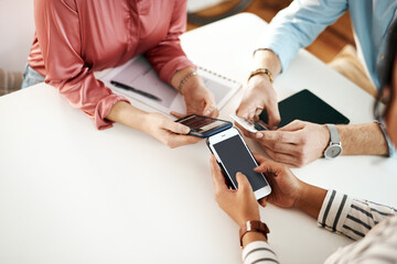 Fototapeta premium We achieve great things with technology and our minds. an unrecognizable group of businesspeople sitting together and using their cellphones during a meeting.