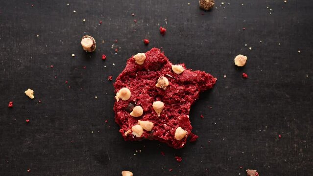 Time lapse of red chocolate cookie with chips being bitten on black table