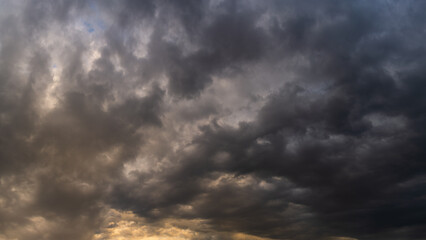 stormy dramatic sky with dense rain clouds and backlight
