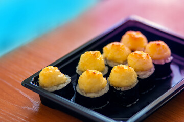 A set of rolls with crab and cheese are in a plastic bath for delivery