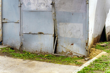 The metal garage door is broken and concave inwards