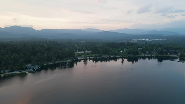 4K Aerial Drone Arc Orbit of Sunrise over Lake Placid with Mountains. Reflections in lake