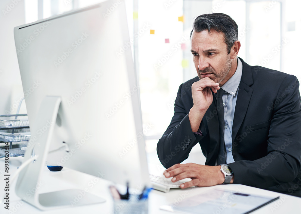 Poster working hard so he can remain on top. a mature businessman working on a computer in an office.