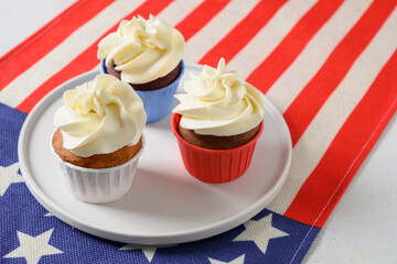 Traditional American three sweet cupcakes in white plate and USA flag. Dessert for Patriotic Independence Day 4th of july.