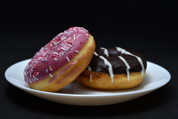 Delicious sweet donuts on a plate. Glazed doughnuts.