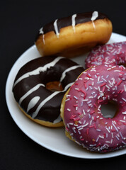 Delicious sweet donuts on a plate. Glazed doughnuts.