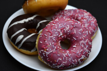 Delicious sweet donuts on a plate. Glazed doughnuts.