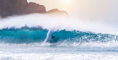 Obraz premium young adult surfing on a big wave in the ocean