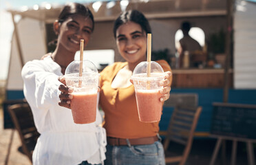 Two friends enjoying the sun. two friends enjoying smoothies together.