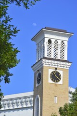 old clock tower Built of bricks in Asian style. White at the top of the tower and the arches of the...