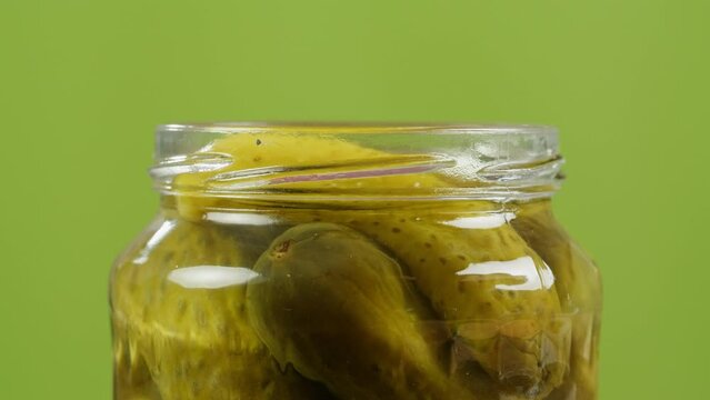 Woman opening Salted pickles in jar can, Cucumbers preservations, conservation. Salted, Hungarian pickled cucumbers in a jar on an old wooden table in the garden with herbs, dill, garlic Generative AI