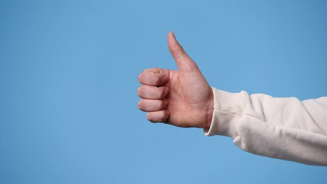 4k video of one human hand which showing thumbs up over blue background.