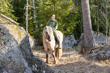 Icelandic horse and camouflaged woman in Finnish spring enviroment