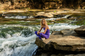 Meranda on rock near waterfall