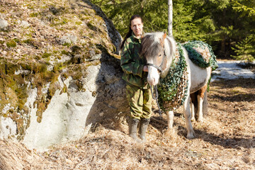 Camouflaged icelandic horse and woman in Finnish spring enviroment