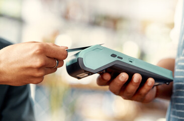 Spending money left and right. a man using a nfc machine to make a card payment at a restaurant.