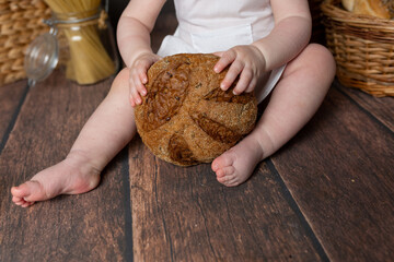 the child is holding a roll. fresh pastry