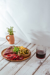 Beef jerky with spice. Red wine in a glass