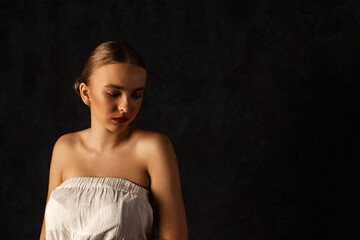 Pensive cover teen girl model 15 year old with clean skin posing at black background, thought....