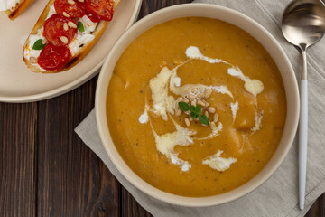 Pumpkin puree soup with cream, decorated with pine nuts