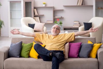 Old man with many pillows at home